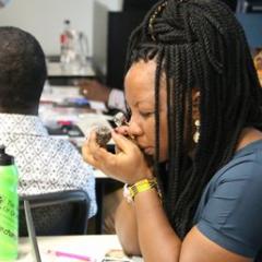 student inspecting a rock in a classroom